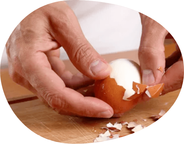 Hand peeling hard boiled eggs