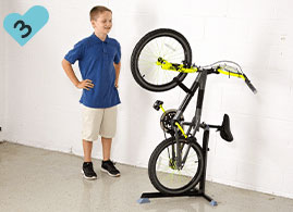 Boy has successfully placed his bike upright in the Bike Nook